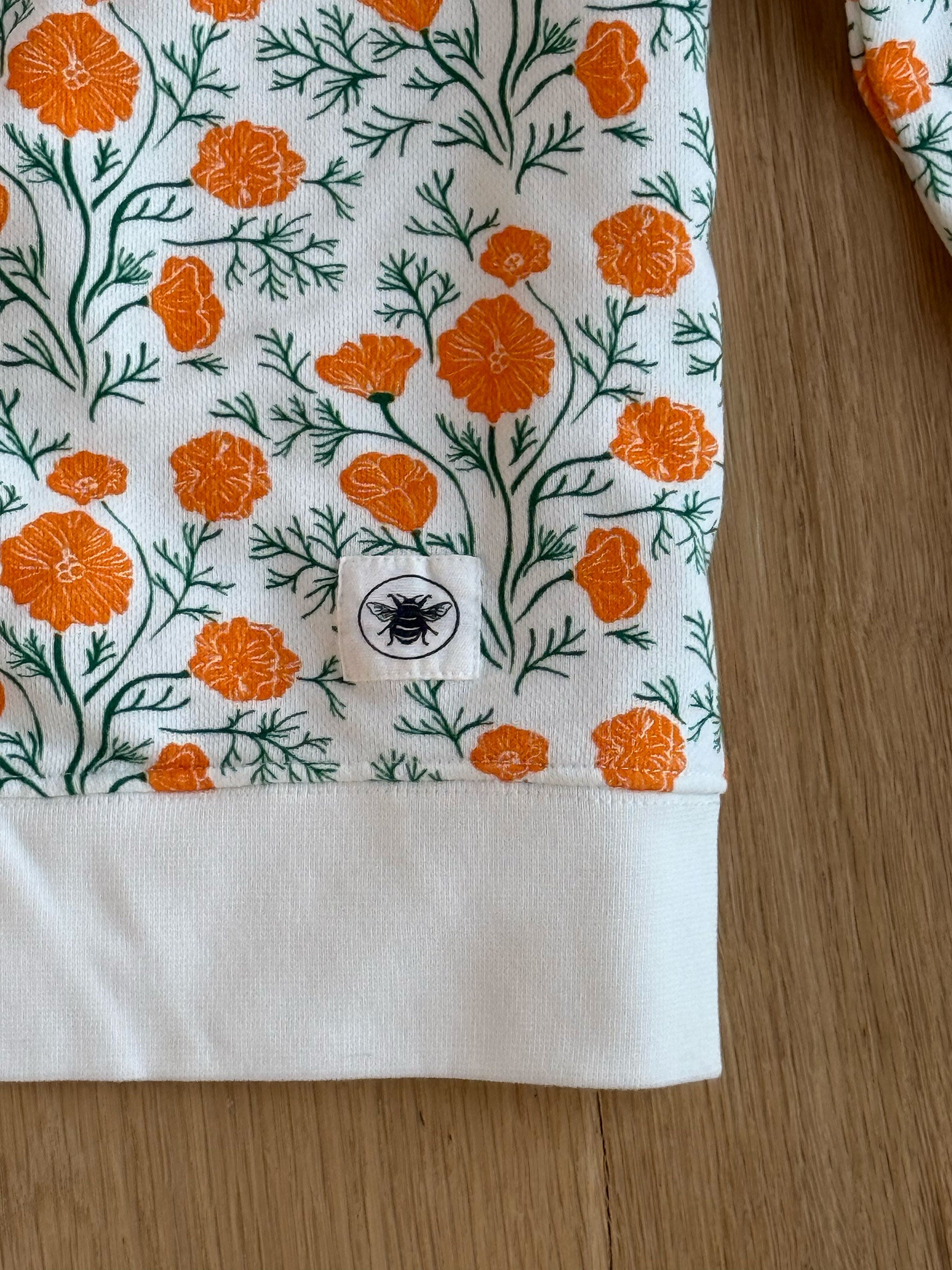 detail shot of california poppies decomposition sweatshirt branding and pattern